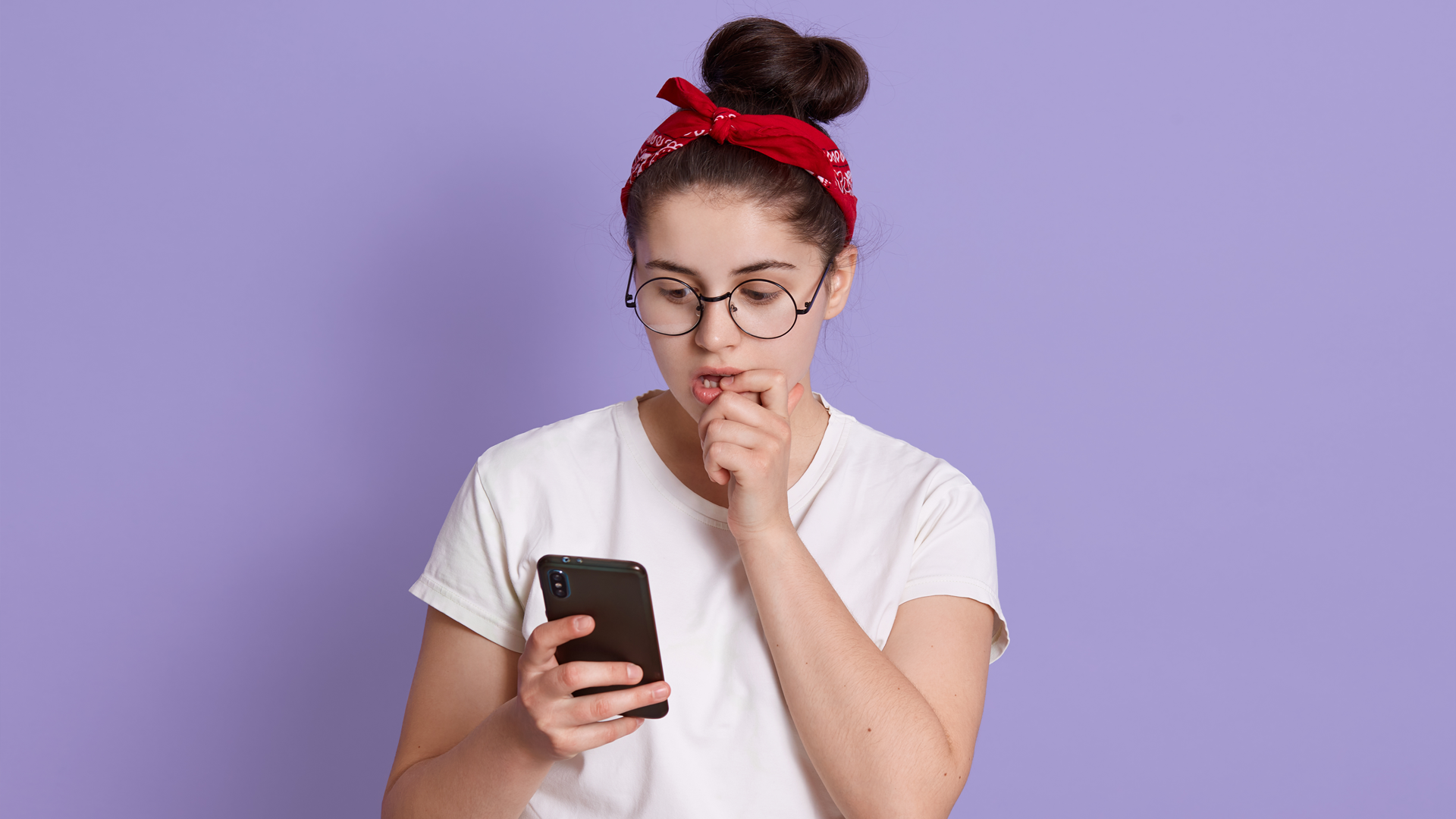 mulher pensativa olhando para o seu celular 